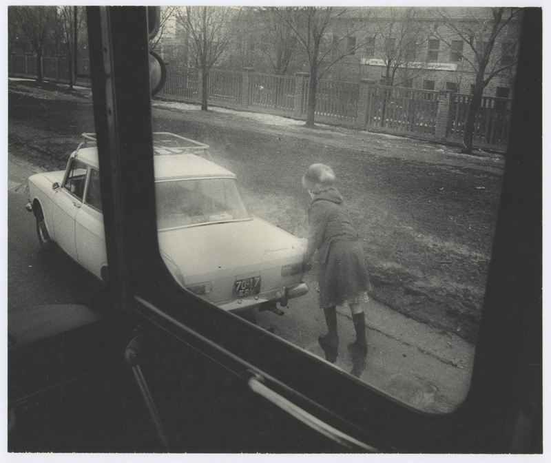 View through the car window: a woman pushing the car.