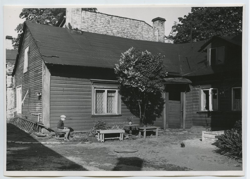 Tallinn, view of the wooden house part of the courtyard. Keldrimäe settlement. In the picture, a small boy is sitting. In the back of the closet.