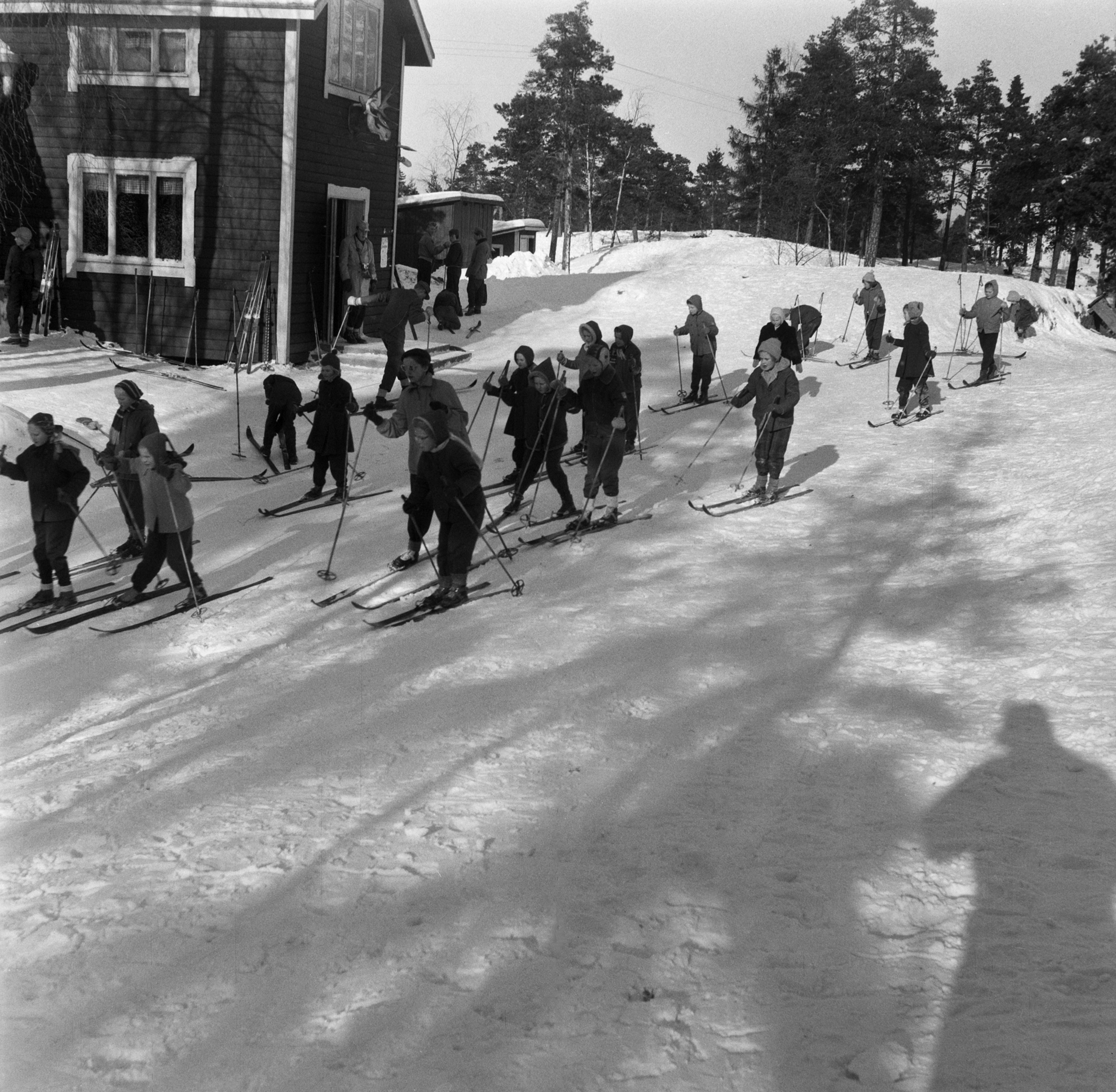 Lapsia hiihtämässä liikuntatunnilla Herttoniemessä, Hirvenpään majan edessä.