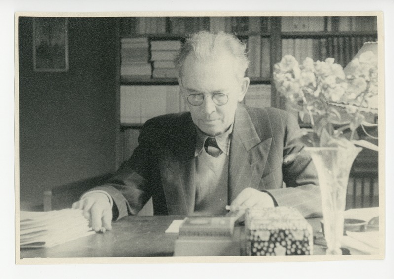 Friedebert Tuglas kirjutuslaua taga lugemas