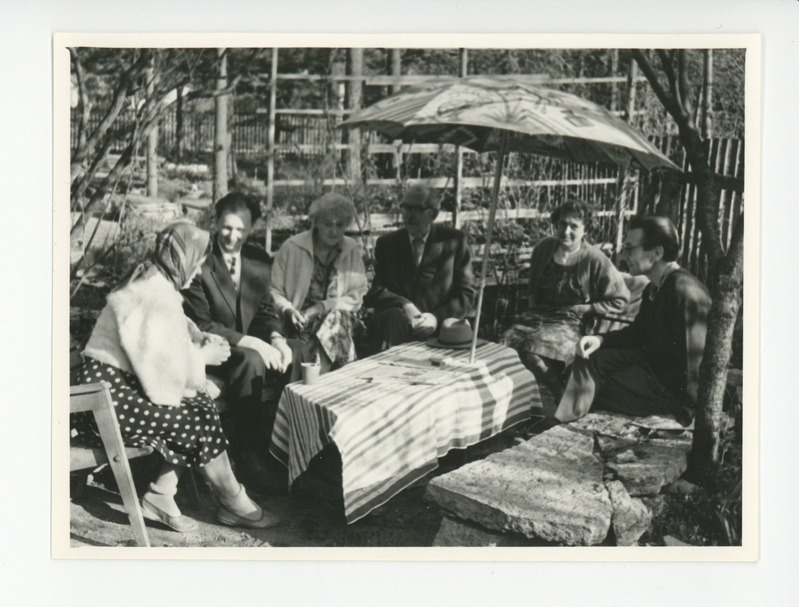 Tuglased külalistega aias päikesevarju all