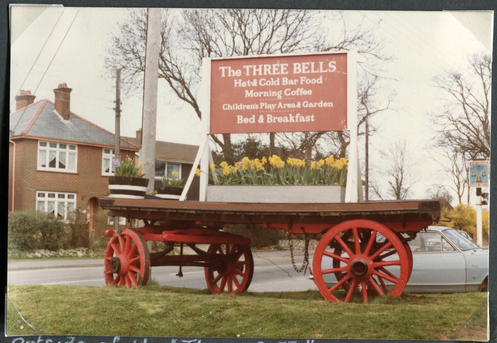 Outside of the "Three Bells" at  Hordle.  The old farm cart is an invitation to call.