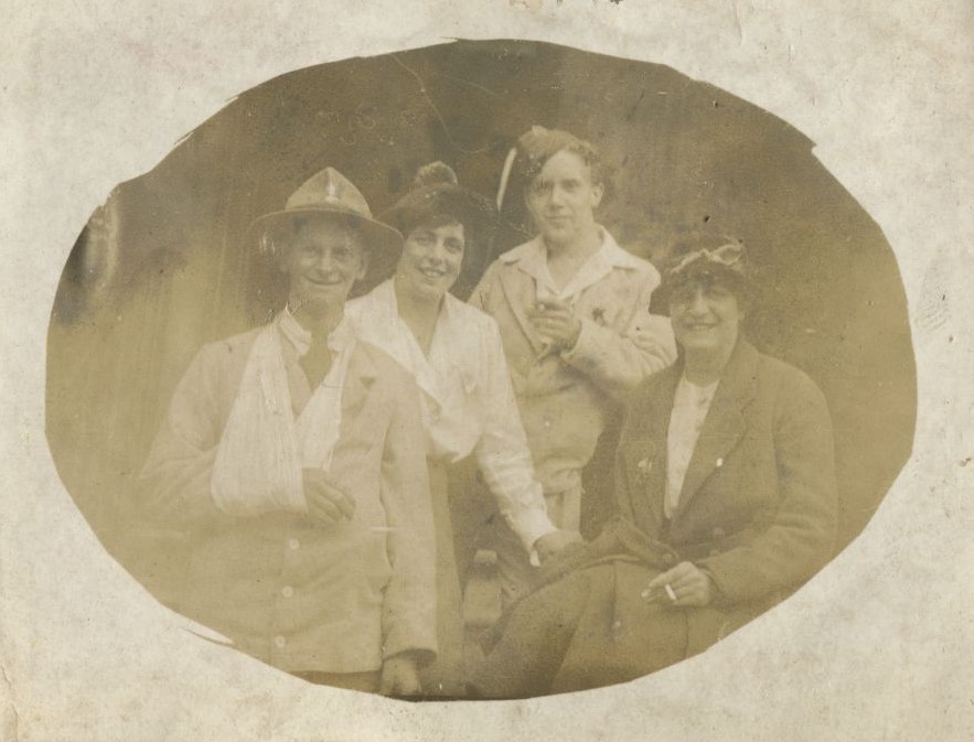 Man with arm in a sling with two women and another man.