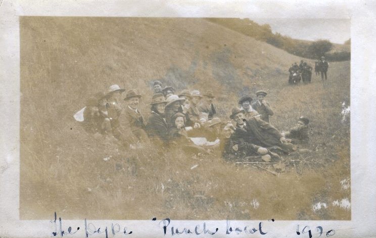 Group seated on a grassy bank with another group of people walking towards them, The Dyke, 'Punch Bowl', 1920