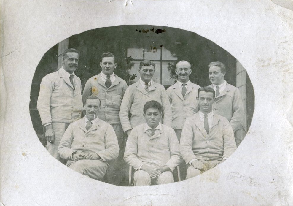 Group of men, five standing and three seated in front, patients, posed outside 'Homemead', Lymington, 1918