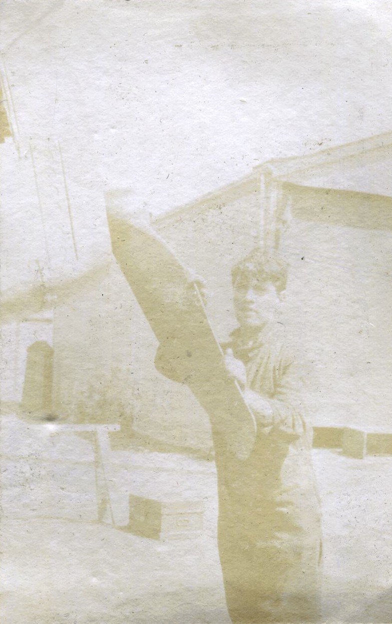 Man leaning on bi-plane propeller, 1915