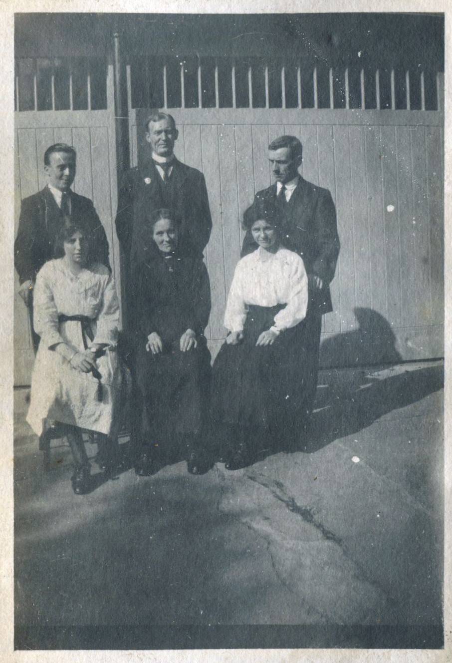 Posed group of three men in suits standing and three women seated in front, St Mary's stables, Bedfont, Middlesex, 1920