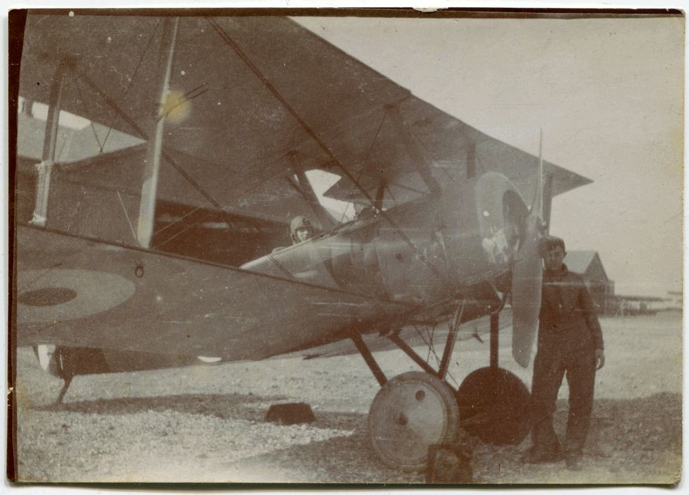 Man leaning against a bi-plane propeller.