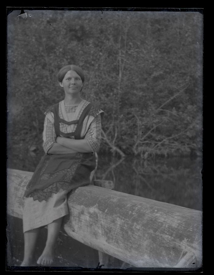 Naine istumas jõeäärsel piirdel.