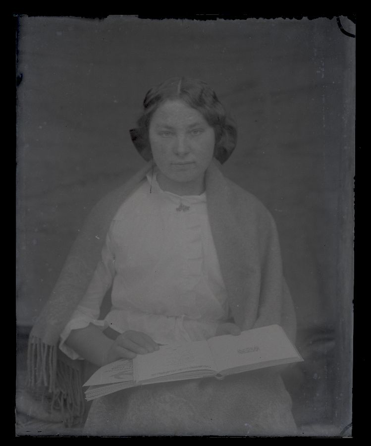 Naise portee, süles kaks raamatut.