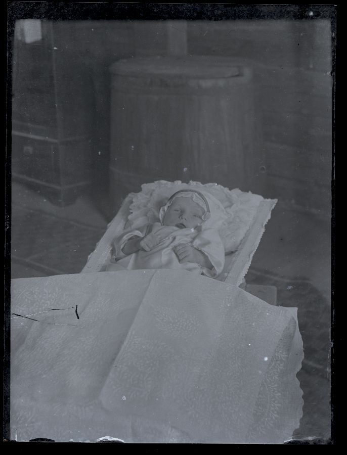 Matusefoto, väikese lapse surnukeha avatud kirstus.