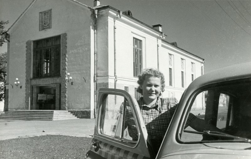 Kino Pobeda, esiplaanil taksosse istuv naisterahvas