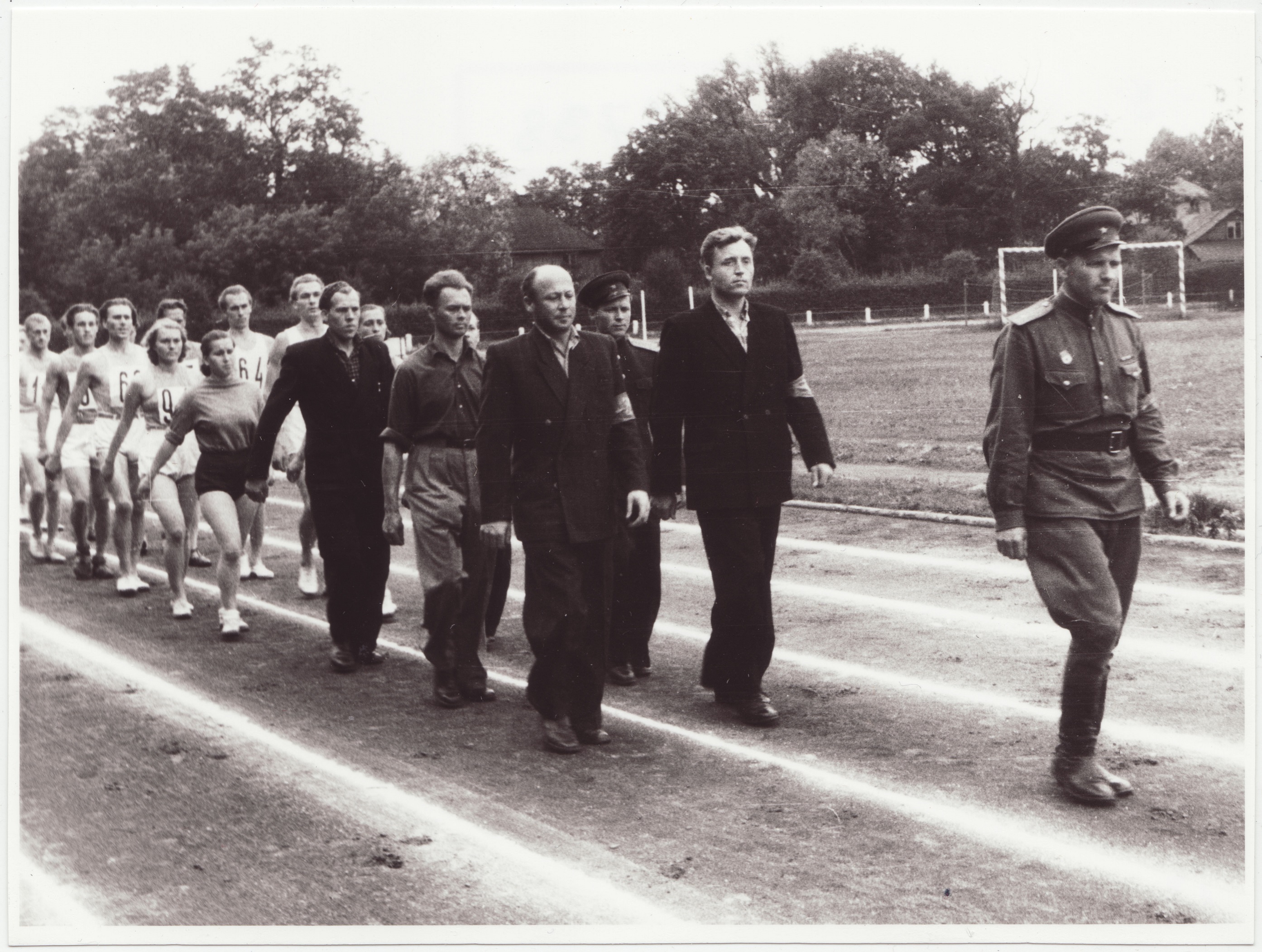 Tallinna sõjaväestatud tuletõrjekomandode kergejõustiku võistluste võitjate autasustamine Dünamo staadionil: kohtunikud ja võistlejad marssimas, 1953.a.