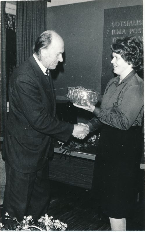 Foto. Vladimir Parbuse 60. sünnipäev. Juubilari õnnitleb pearaamatupidaja Juta Tau. Foto V. Pärtel, 1984