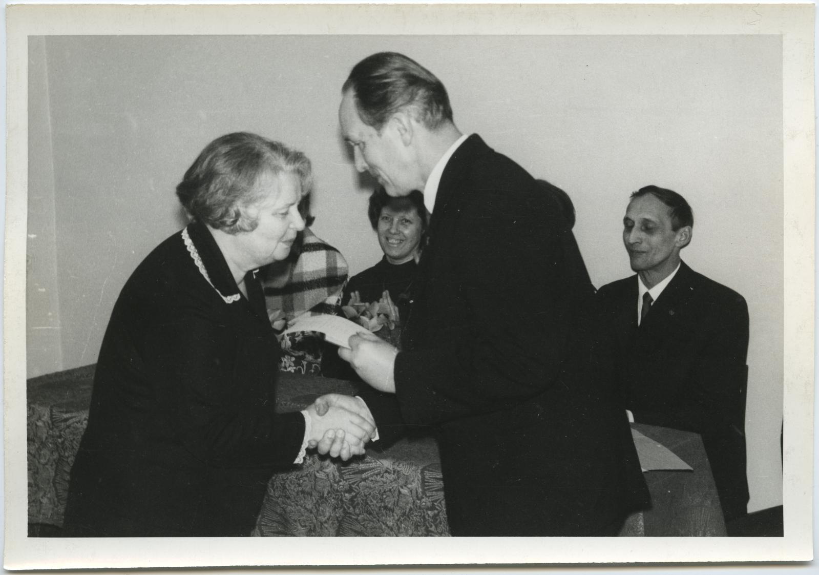 VII lennu lõpuaktusel 6. veebr. 1971. Kursuse juhataja Eduard Maaser õnnitleb lõpetajat Linda Räätsa.