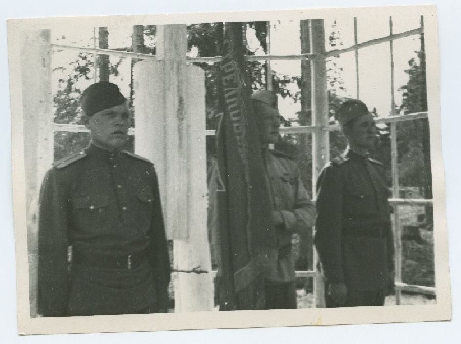 Ohvitser ja kaks sõdurit lipuga, enne selle heiskamist 300. polgu laagri avamisel, 1945. aastal Kloogal.