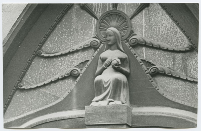 Puust valmistatud istuva naise kuju Müürivahe tänav 26 maja uksel.