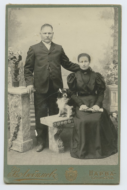 Ateljeefoto abielupaarist koos koeraga.