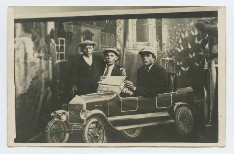 Laadafoto, kolm meest autos maalitud tausta ees.