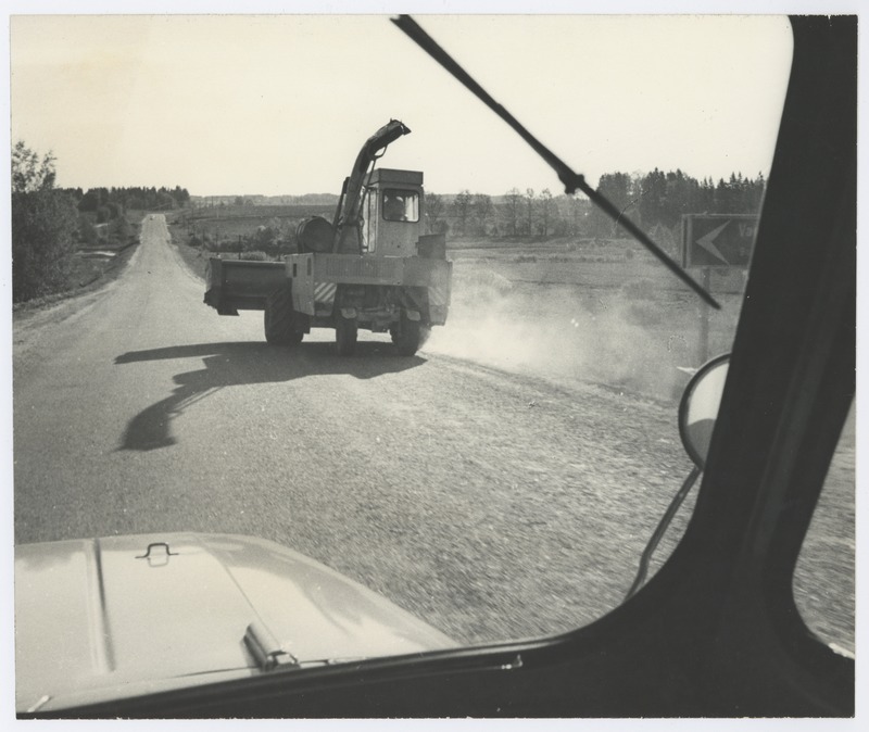 Vaade läbi autoakna: teel sõitev kombain.