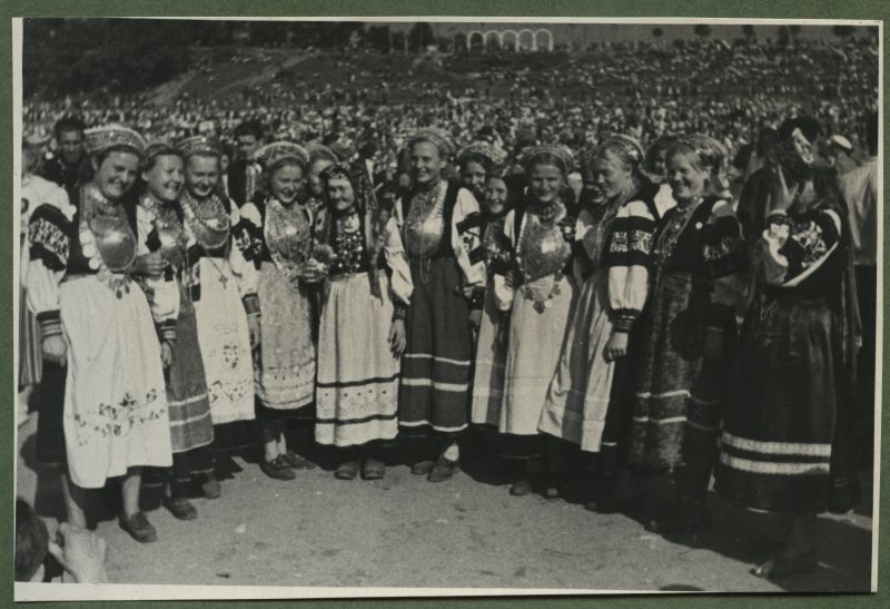 XII üldlaulupidu 28.-29. juunil 1947, Tallinnas.
Seto rahvarõivais neiud 12. üldlaulupeol Tallinna lauluväljakul. Neidude rindasid ehivad suured Seto sõled. Taustal paistab lauluväljaku mägi, kus paiknevad pealtvaatajad.