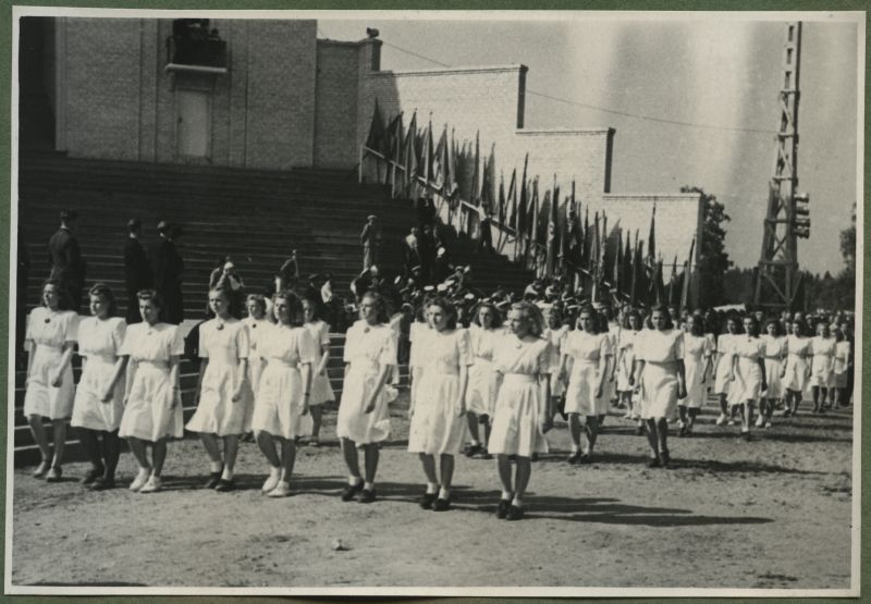 XII üldlaulupidu 28.-29. juunil 1947, Tallinnas.
12. üldlaulupeo rongkäigulised jõudmas Tallinna laululavale. Valgesse riietatud, sõlgedega ehitud neiud rongkäigus Tallinna lauluväljakul. Taga paistab Tallinna vana laululava, mis on ääristatud erinevate lippudega.
