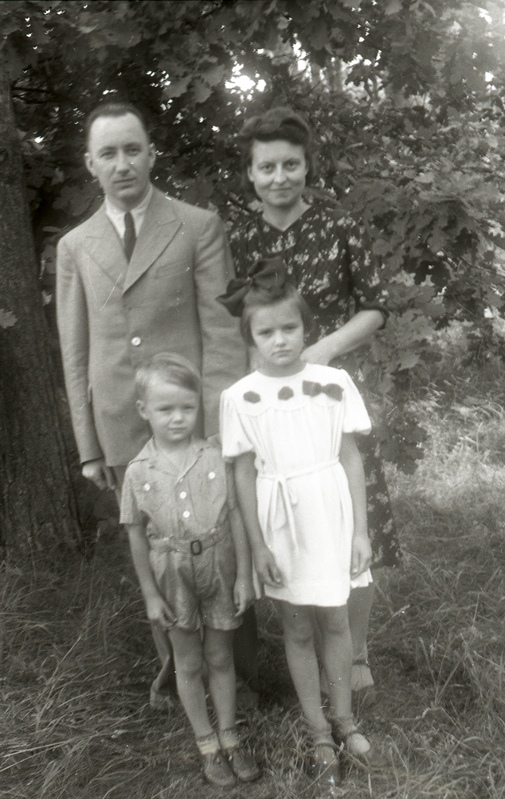 Mees ja naine kahe lapsega puu taustal seismas