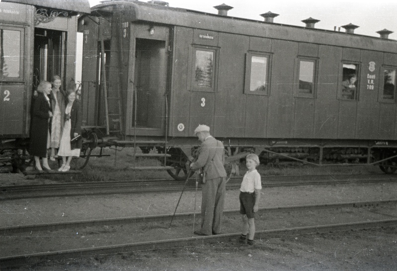 Kolm naist rongil foto jaoks poseerimas, fotograaf ja poiss raudteerööbastel seismas