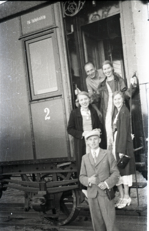 Kaks meest ja kolm naist rongil ja selle ees seismas