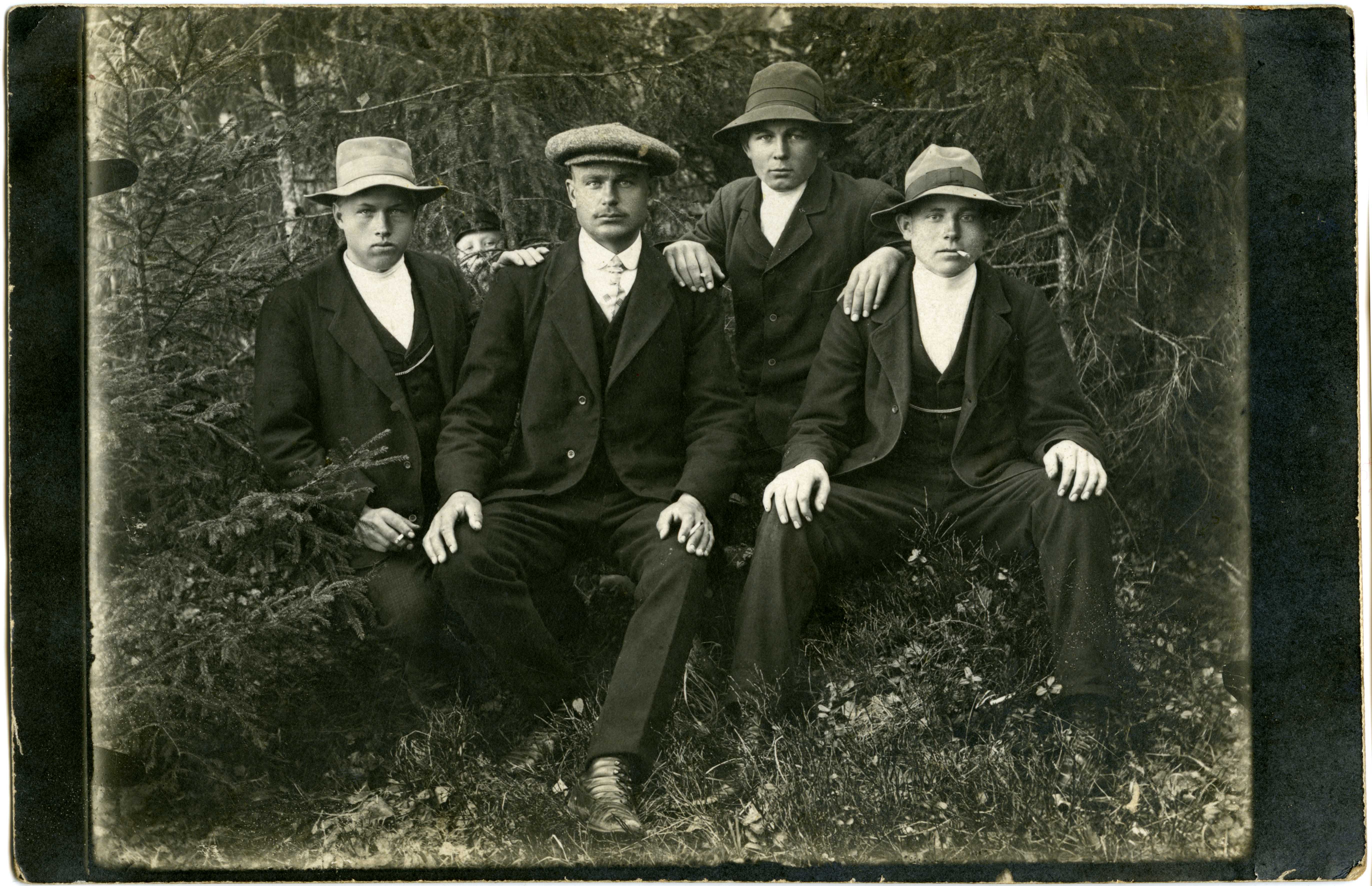 Grupipilt: neli istuvat meest kuuskede taustal; (Türi ümbrusest).