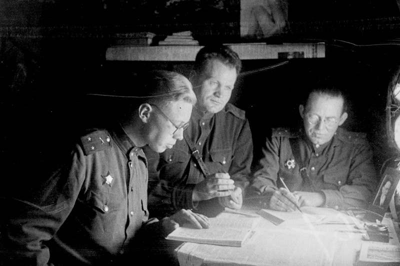 Kolm komandöri, vasakult: leitnant Mannermaa, kapten Pauming, v. ltn. Urb 779. Suurtükiväepolgust istumas laua juures, 17.märtsil 1945.a.