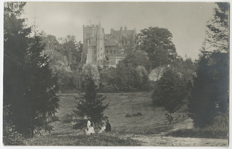 Esiplaanil inimesed murul istumas, tagaplaanil Sangaste loss