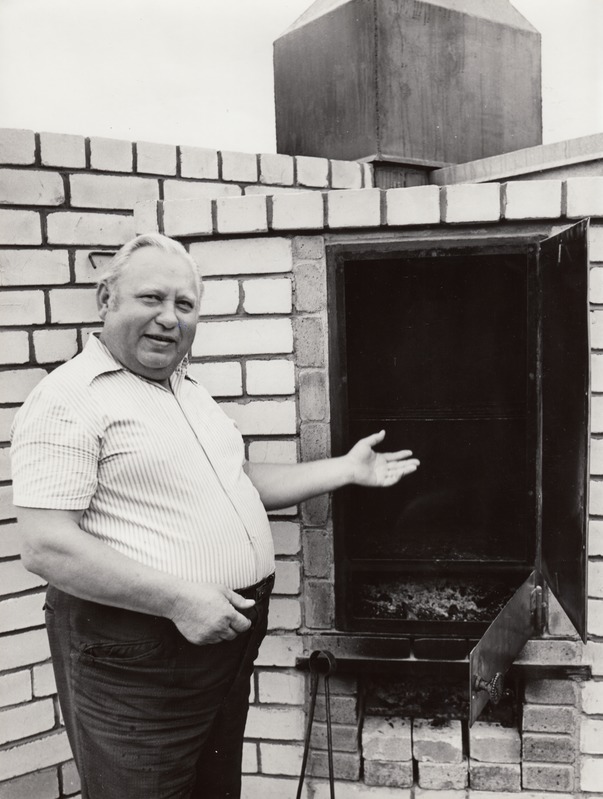 Kaiu kolhoosi suitsuahju kõrval seisab Viktor Aljamaa