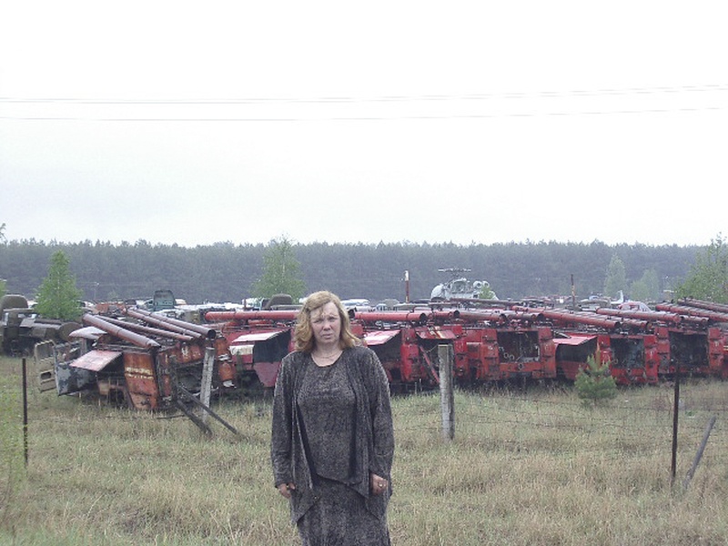 Taas Tšornobilis, mahajäänud masinapargi taustal Tšornobili veterani abikaasa