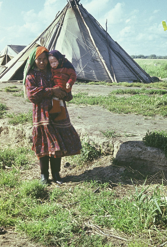 Handi naine lapsega püstkoja ees. Jamali Neenetsi rahvusringkond Šurõškarõ rajoon Lophari külanõukogu ja suveküla.
Foto 1977.