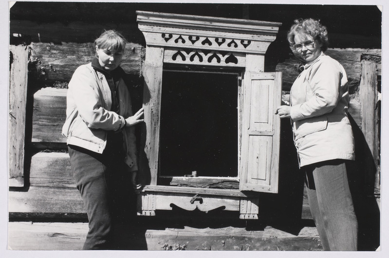 Kaunistatud aken. Akna kõrval seisavad ERM-i osakonnajuhataja Mare Piho (vasakul) ja soome etnograaf Marjukka Patrakka.