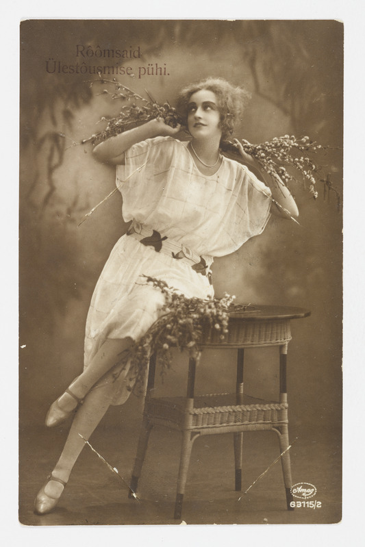 Romantiline lihavõttekaart lauale nõjatuva pajuokstega naisega ning tekstiga "Rõõmsaid Ülestõusmise pühi"