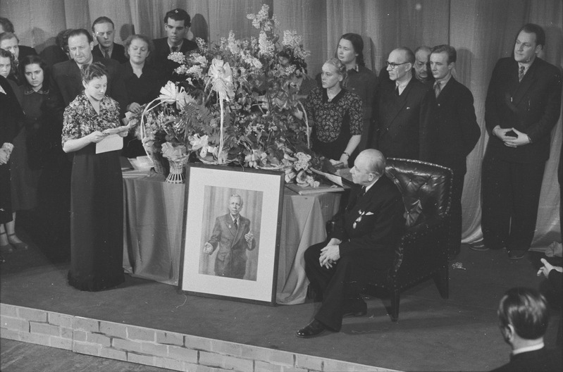 pildil: Hugo Laur, 60. juubel, Draamateatris, juubilar istub, Inna Taarna loeb ette õnnitlustelegramme