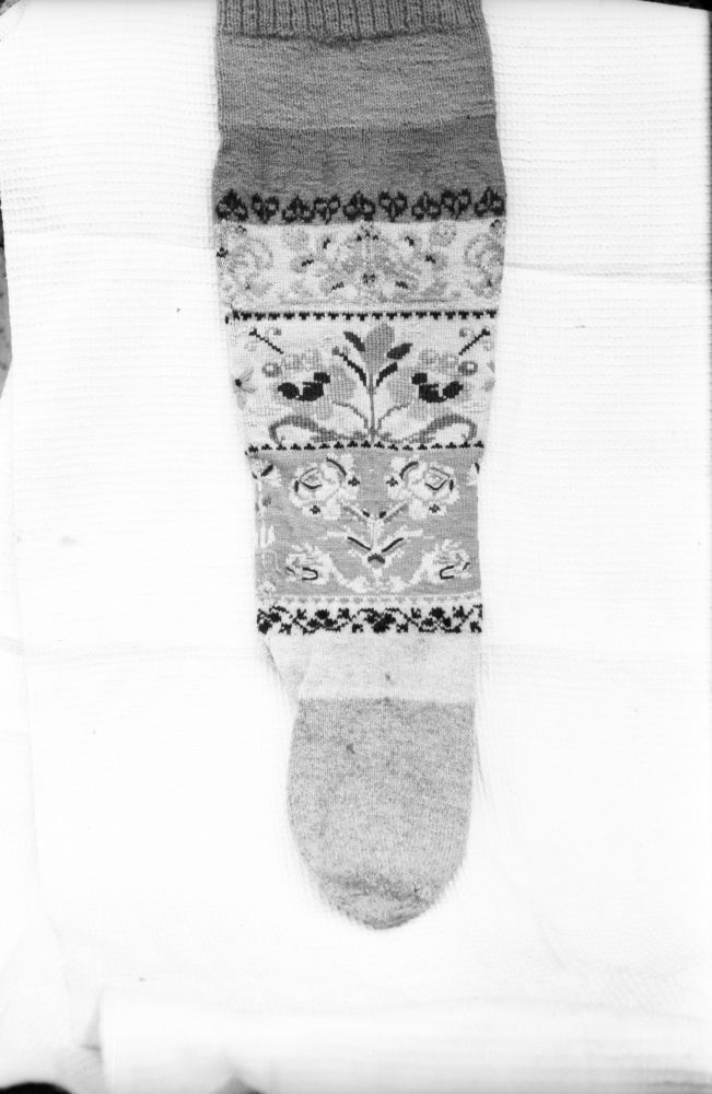 Kootud lillkirjadega sukk.