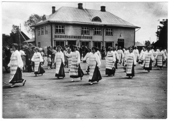 Kärdla kultuurimaja naiskoor "Heliko"  laulupeo rongkäigus keskväljakul majapidamistarvete kaupluse ees