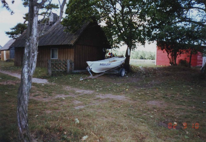 Kõpu küla Pihla talu vaade õuele, kus keskel paat, selle asemel oli kunagi sepikoda, kahel pool hooned.