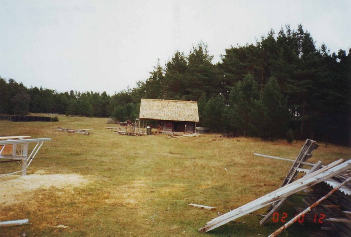 Kalana küla sepikoja restaureerimine meremuuseumiks üldvaade , esiplaanil lagendik, ehitusehitusmaterjali , hoone keskel , selle taga ja paremal mets.