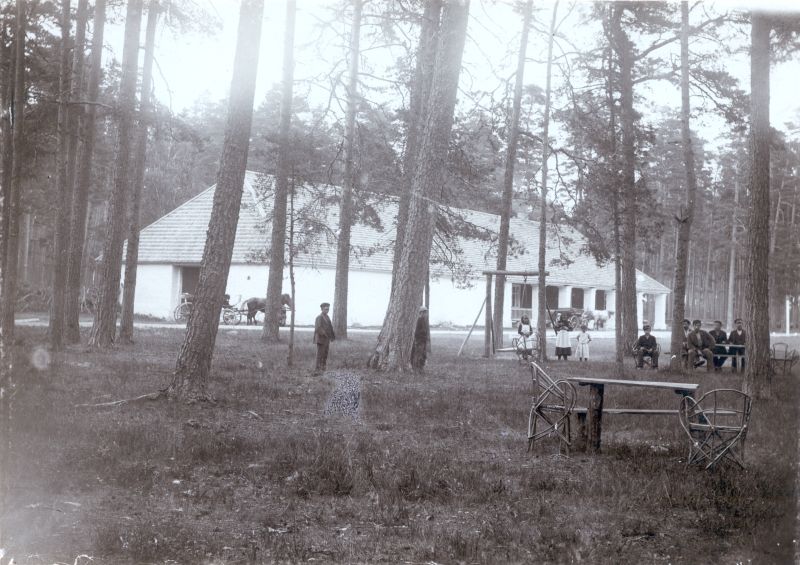 Foto. Ungru-Paralepa kõrtsihoone mändide vahel. Esiplaanil laud toolidega, keskplaanil poisid ja tüdrukud. Foto Th. Haack. u. 1900.