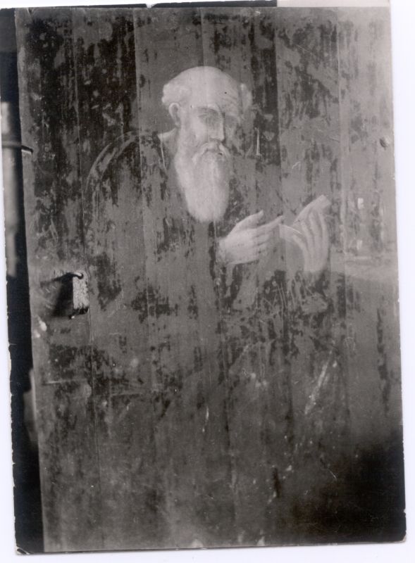 Foto. Maal puidul, mis kujutab hallipäist pika habemega meest raamatut käes hoidmas ja lugemas. 1938.