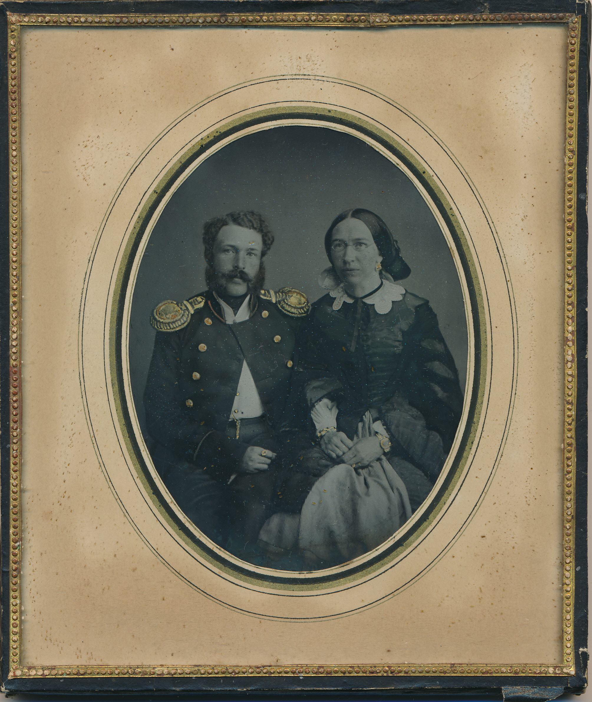 Foto. Ambrotüüp - Abielupaar istumas, mees sõjaväelase vormiriietuses, u. 1870, Paspartuu, klaasi all