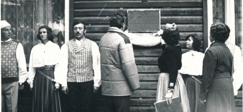 Foto.  Heljo Talmeti mälestustahvlilt eemaldavad katte (vasakult) Haapsalu Rajooni RSN TK esimehe asetäitja Lembit Kask, rahvatantsujuht Helgi Miller ja EKP RK II sekretär Laine Soosalu.  30.september 1982.a.
Foto: Tenno Sillaste.
