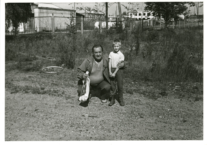 Jüri Lehtrand koos väikese Viktoriga Toguri lastekodu värava kõrval