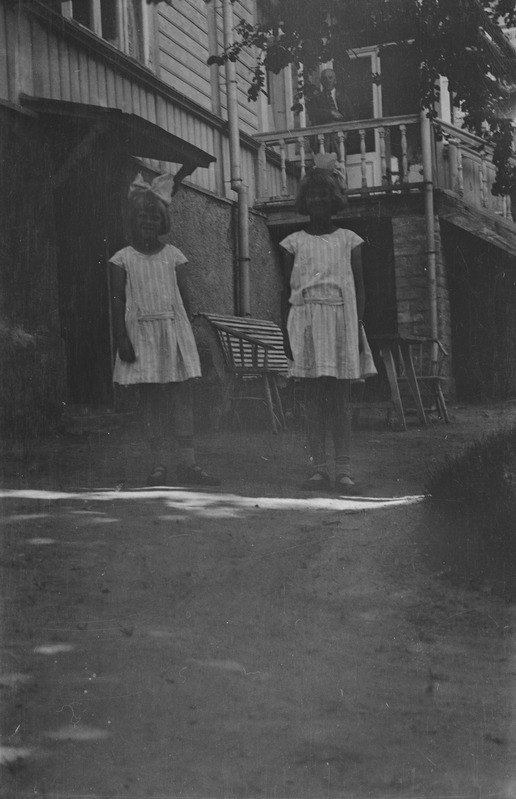 Kaks tütarlast maja ees