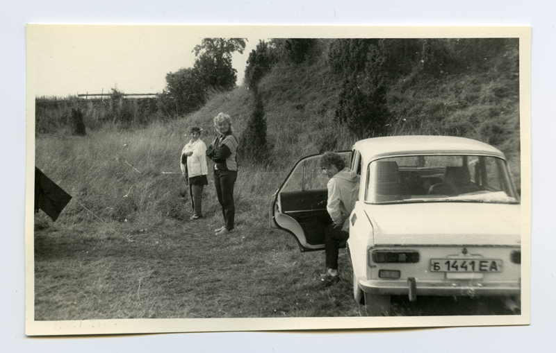 Allveearheoloogia klubi "Viikar" telklaager Maasilinna ordulinnuse vallikraavis. Telkide vahel Vaike Raudsepp, Katrin Sepalaan. Autost astub välja Taimi Mäss. 
1987