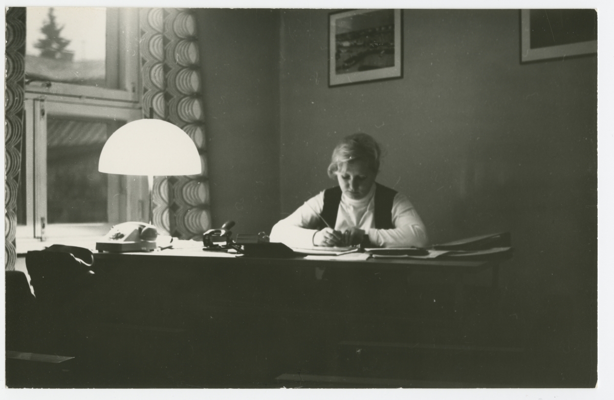 Alla Barslaja - Pärnu Õppekursuste Kombinaadi direktori asetäitja õppealal - oma kabinetis kirjutuslaua taga töötamas